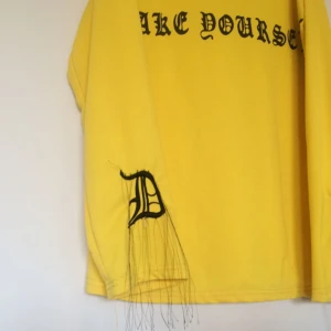  - Gul tröja med svart text på ryggen och detaljer på ärmarna. Jag är 178cm lång och brukar använda den som "klänning" med ett par shorts under.