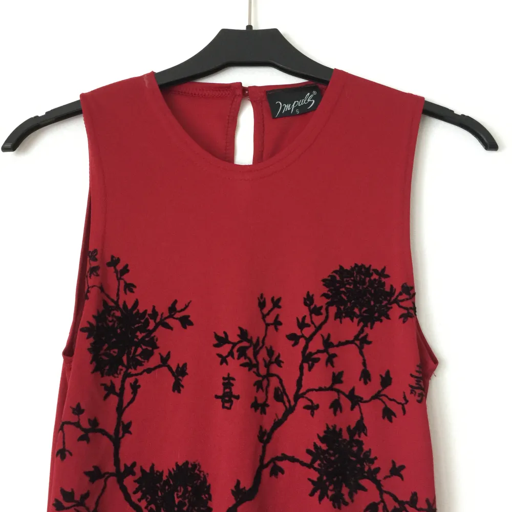 Mörkröd ärmlös tajt långklänning i asiatisk stil. Vackert asiatiskt blommönster. Klänningen kommer från Impuls, en gång ett undernärke hos H&M. Den har aldrig använts, köptes nån gång 80-tal/-år 2000. . Klänningar.