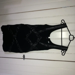  - Klänning från bik bok i nyskick svart med skinbetaljer