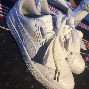  - Vita lackade sneakers med guld detaljer & breda snören Storlek: 38 Skick: Använda ca 5 gånger, små märken fram på skon som uppstår efter två användningar. Superbra skick Pris: 400kr. Alla priser kan diskuteras. 