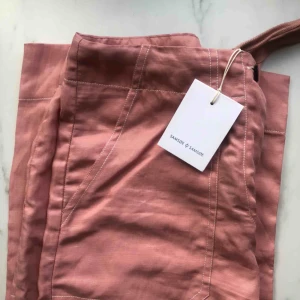  - Ljusrosa wide leg byxa i tunt och mjukt material från Samsøe & Samsøe! Har även en dragband som kan justeras. Aldrig använd med lappen på. Säljer pga att de inte riktigt passade.Jag står för frakten👍🏻 kan även mötas upp! 