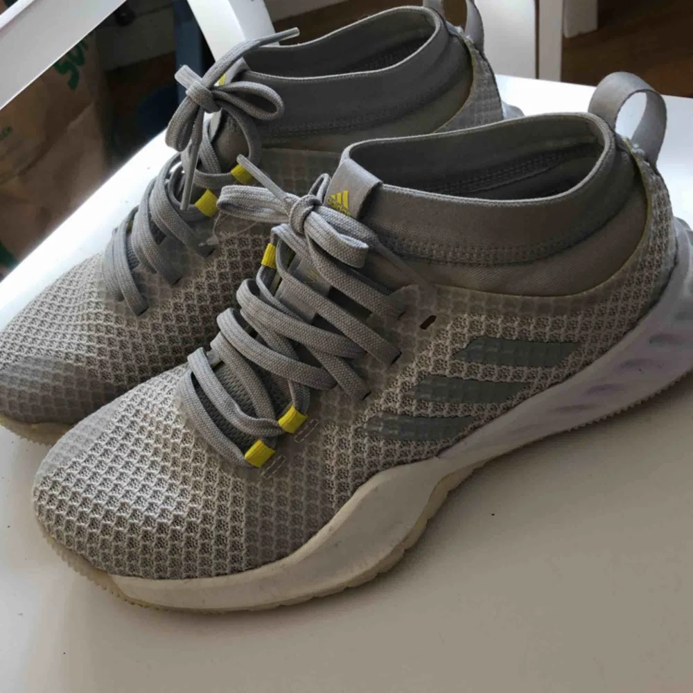 Nya ljusgrå Adidas löparskor med gula smådetaljer, strl.38. Endast använda vid ett kort tillfälle, så dom är i toppenskick. Säljer dom för att dom är för smala för mina fötter tyvärr.. Skor.