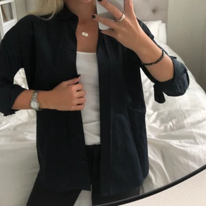 Marinblå skjorta från J Lindeberg - Marinblå oversizeskjorta från J Lindeberg. Mycket gott skick, använd 1 gång. Frakt ingår!