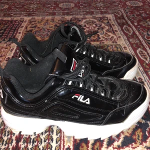Fila disruptor - Tvärfeta fila skor i svart lack. Skitsnygga och bekväma! Superduperbra skick!!! Du får med den putsen (sista bilden). Ca 100kr i frakt
