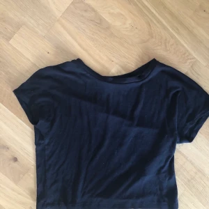 Svart kortare T-shirt  - Fin svart, lite kortare T-shirt från zara. Nyskick.
