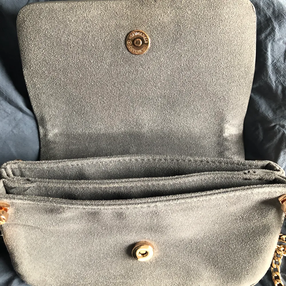 Söt grå/blå väska från h&m med guldig kedja💙. Väskor.
