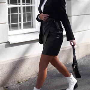 Kjol - En skitsnygg skinnimiterad kjol som man knyter omlott 🖤🥰 Jag älskar att styla den till en vanlig vit skjorta eller som på bilden med en vanlig tröja och kavaj över 💕 BUDGIVNING I KOMMENTARERNA (kan skickas mot fraktkostnad) 