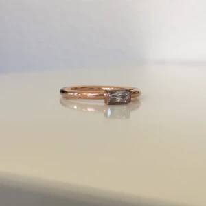 Ring från Edblad - Oanvänd ring från Edblad. Färg: rosé, med genomskinlig sten. Storlek: 18.