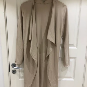 Tunn kappa från New Yorker. Strl L - Säljer en fin beige kappa från New Yorker. Själv är jag en strl XS/S men denna sitter bra på mig. 