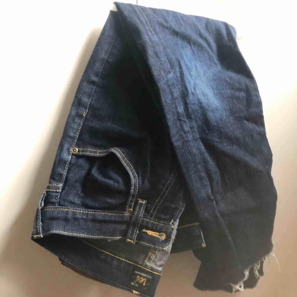 Ett par mörkblåa lee-jeans. Köpta secondhand så är lite osäker på storleken. Jeansen är avklippta och avslutas ungefär vid ankeln . Jeans & Byxor.