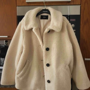  - Teddyjacka i en gräddvit nyans. Aldrig använd!  Priset kan diskuteras.      .     (Frakt tillkommer)