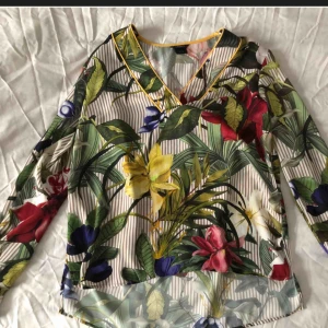  - Blus med blommor och längre bak