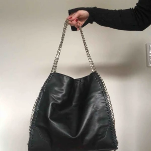  - Handväska från Nelly. ett stort fack som stängs med en tryckknapp och två inner fack, ett med dragkedja.  Sparsamt använd.