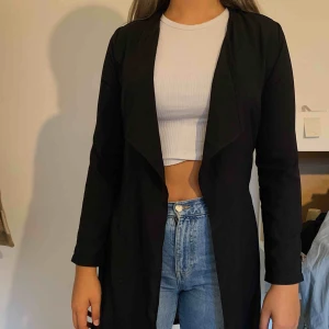  - En tunn svart kappa från gina tricot i storlek XS. 