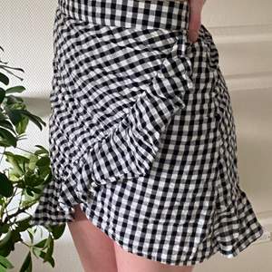 Fin kort rutig kjol från bikbok med volang i kanten. 100% ekologisk bomul. Använd fåtal gånger.