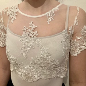 Spetstopp från Rebecca Stella i storlek S - Vit spetstopp från Rebecca Stella, använd ett fåtal gånger så i fint skick. Står storlek M i den men VÄLDIGT liten i storlek så snarare en XS/S. Vita linnet under medföljer inte utan enbart spetstoppen. 