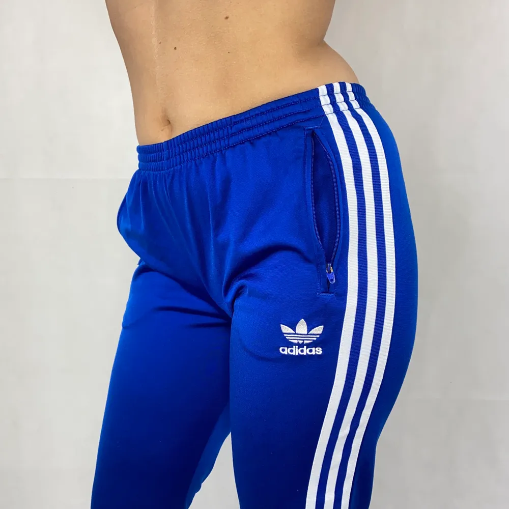 Trackpants från adidas i toppenskick. Säljer då dom var för korta för min smak. Dom glänser fint i ljuset! Sitter superfint. Stretchig midjeband. Innerbensläng är 72cm. Modellen använder vanligtvis S och är 169cm. SafePay knappen är aktiverad så det går att köpa direkt utan att behöva meddela! Tar annars swish! (Safepay tar 10% av betalningen och spårbar frakt på 66kr är inräknad i priset) Skriv gärna om du har eventuella frågor!. Jeans & Byxor.