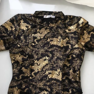 Klänning - Svart klänning med guldmönster. Inspirerad av kinas traditonella silkesklänningar. Klänningen är tight och väldigt stretchig samt formsydd 