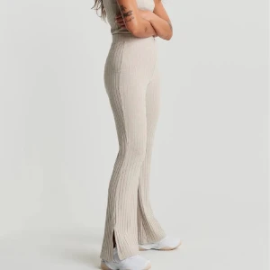 Gina tricot  - Gina byxor, beiga ribbade och med slits. Super snygga passar o längd till alla ända upp till 175 skulle jag säga. Frakten är 66kr🥰