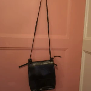 Liten axelremsväska - Jättefin liten axelremsväska i läderimitation från Åhléns.