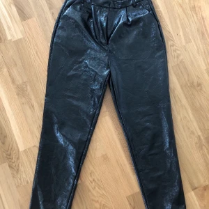 Svarta lackbyxor från NAKD  - svarta lackbyxor. Storlek 40 men är mer som 38