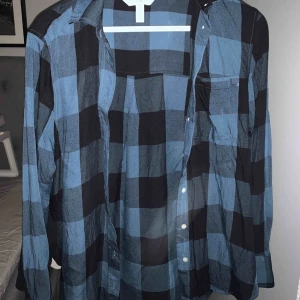  - En skjorta som är snyggast öppen med något under till en t-shirt eller ett linne