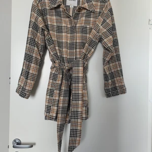 Rutig höstjacka - Så snygg rutig höstjacka med bälte! I fint skick. Snyggt rutigt mönster. Storlek xs men passar xs-l beroende på hur man vill den ska sitta. 