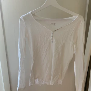 Tröja med knappar - En vit vanlig långärmad tröja med knappar fram till. Väldigt fin på ! Använd 3-4 gånger max ! Lite skrynkligt men försvinner efter tvätten. Tvättar plagget innan säljning. Frakten står köparen för. Skriv om ni har några funderingar !!🤍💓🌸 