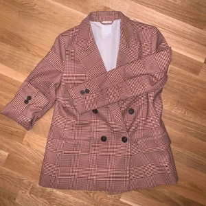  - Rutig/fiskbensmönstrad retro kavaj ifrån H&M! Härlig vinröd färg med beige/vit som bakgrundsfärg. Skick 10/10, använt en gång. Säljer pga har en nästan likadan! 