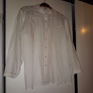  - Vit halvtransparent skjorta med fina detaljer. Märkt med storlek 44 men passar mindre 