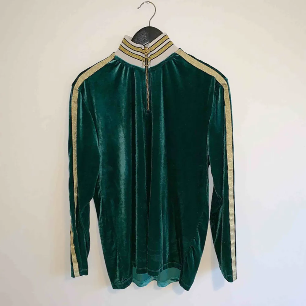 Långärmad t-shirt/polo från ASOS med hög krage och dragkedja i grön velour. Väldigt sparsamt använd. Skick: 8 / 10. Ord pris: 350kr . T-shirts.