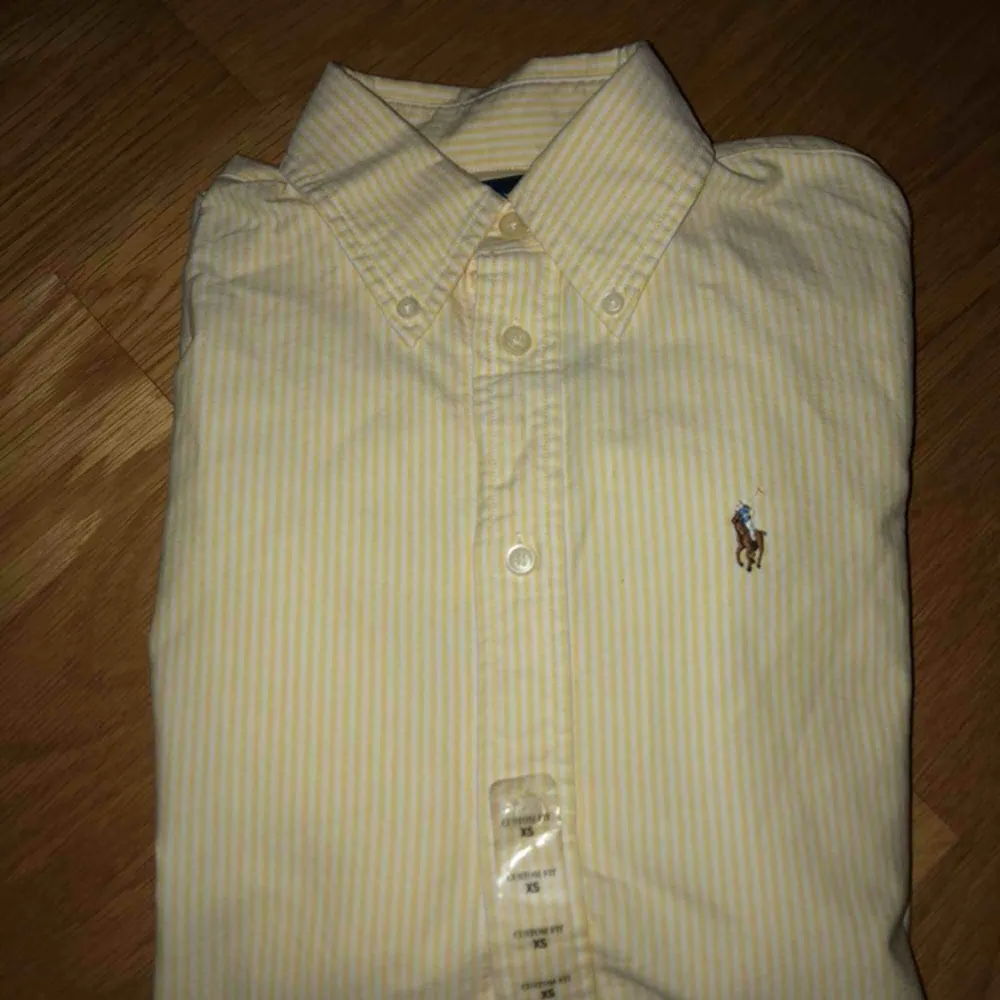 Gul-vitrandig Ralph Lauren skjorta, aldrig använd med prislappen kvar! Därav nyskick. Frakt tillkommer! . Skjortor.