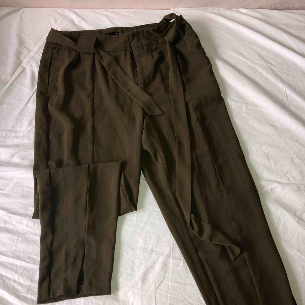 Khaki färgade kostym byxor från Gina tricot, med split längst ner på byxorna. . Jeans & Byxor.