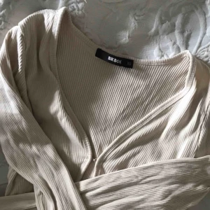  - Tajt ribbad top från bikbok.  Långa armar och normal lång i midjan.  Beige/ljusrosa färg.  Sparsamt Använd.   Ord pris 299kr