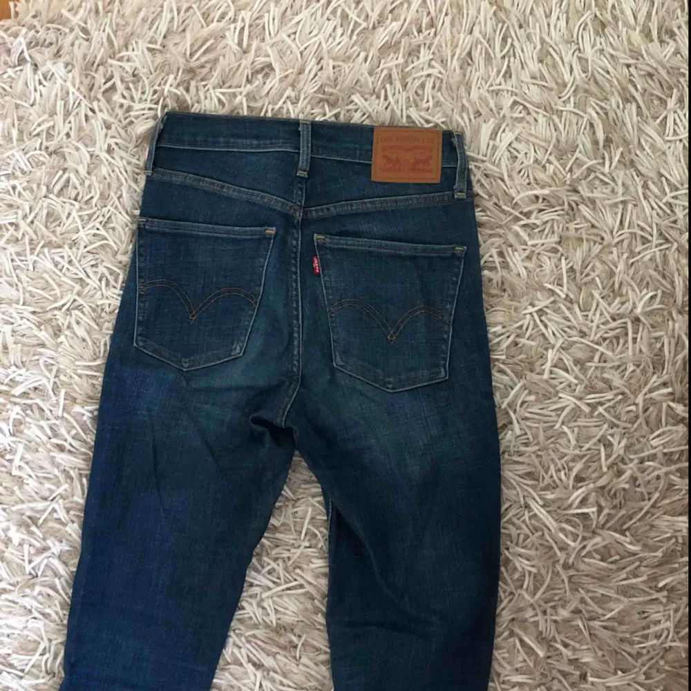 Mörkblå, tajta jeans från Levi’s i deras Mile High Super Skinny modell. Väldigt bekväma. Storlek 25 i midja och 32 i längd.. Jeans & Byxor.