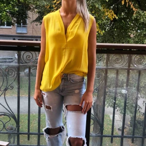  - Lång, söt, gul blus som går att använda på många sätt. Köpt i Mango, som helt ny, inte använd. 