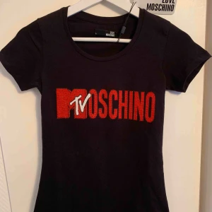 Utförsäljning - Moschino - Helt ny!  - Oanvänd märkes t-shirt från MOSCHINO för tjejer Storlek: S  —— OBS: KÖPAREN STÅ FÖR FRAKTEN! - Frakt med spårnummer kostar 63kr