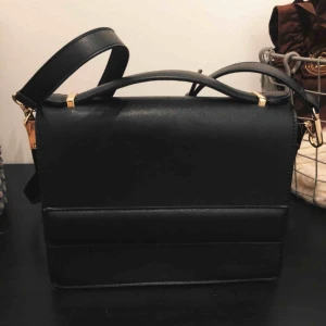  - Svart liten väska, kommer med axelband.