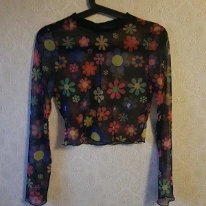 Blommig mesh tröja - väldigt söt croptop mesh tröja. använd en gång och är i bra skick, säljes för 100kr plus frakt elr upphämtning i kalmar. 
