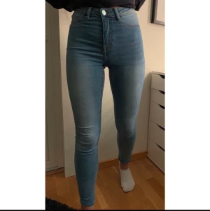Blåa jeans  - Jeans i färgen blå och är hög i midjan med en tajt fit.