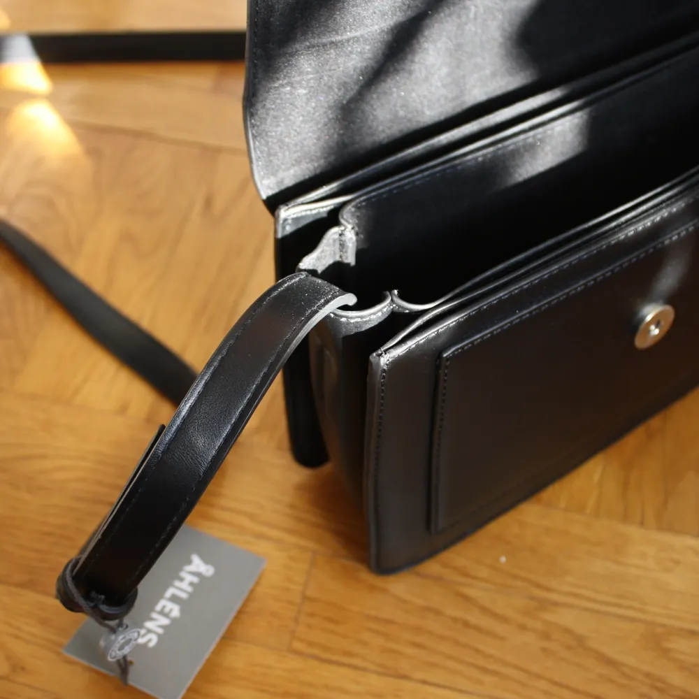 En liten, svart handväska i konstgjort läder. Helt ny och aldrig använd. Nypris 349 kr. Många bra fack, perfekt storlek för en utekväll! Hör av dig om du är intresserad:)). Accessoarer.