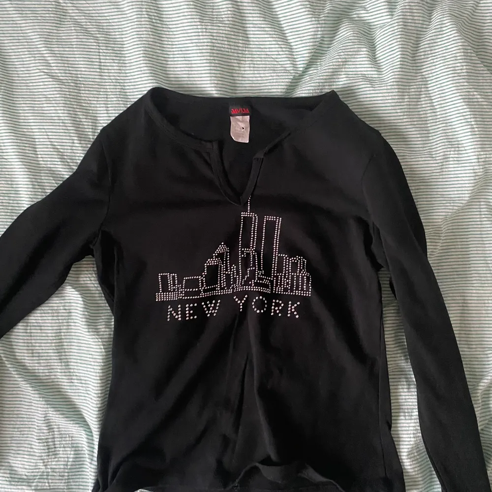 Skitsnygg svart långärmad tröja med en siluett av höghus och new york skrivet i rhinestones<3 st L men passar som en M. Köpare står för frakt💖 säljer pga något kort i ärmarna . Toppar.