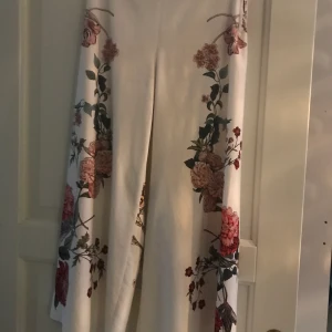 Blommiga byxor - Blommiga vida vita byxor från zara. Väldigt snålt använda, säljer pga dom inte passar längre. Köptes för 500kr