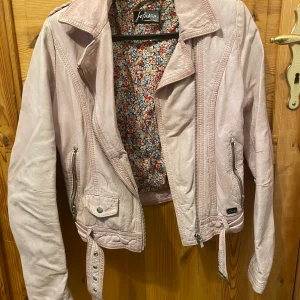 Rosa skinnjacka från jofama  - Skinnjacka från jofama by Kenza. Rosa, några år på nacken men sparsamt använd. I bra skick. Köpt för 2000 kr. Storlek 32 men passar även 34-36 beroende på hur man vill att den ska sitta. 