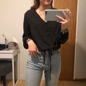 Urringad svart blus - En urringad svart blus med knytning vid midjan. Helt oanvänd så i bra skick från Lager 157. Säljer för 50kr + frakt. 