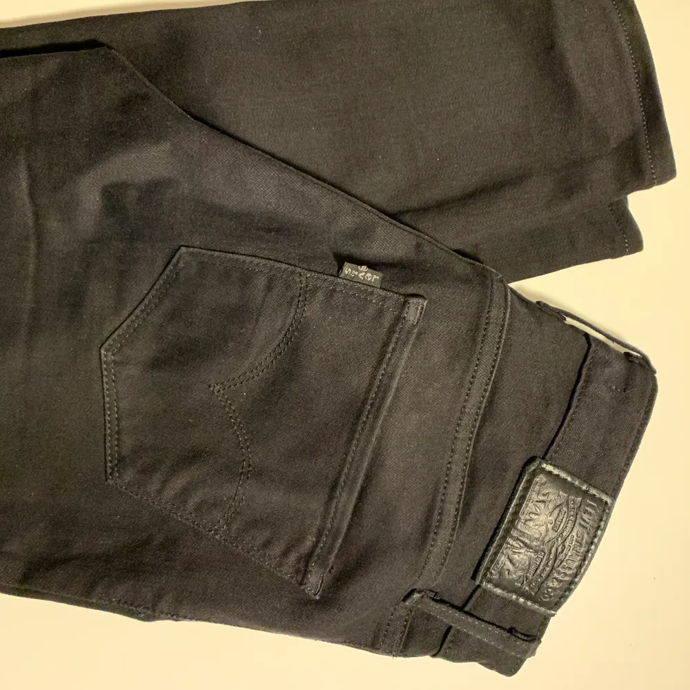 Svarta, högmidjade Levis jeans i storlek 25. Nyskick utan slitningar eller bleknad färg.. Jeans & Byxor.