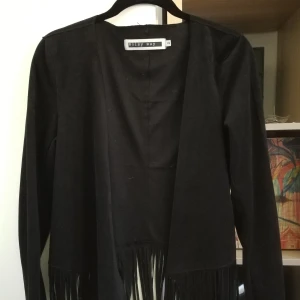 Kavaj med fransar xs  - Väldigt fin svart kavaj i lite sammets liknande tyg. Rätt tunnt material. Kommer tyvärr aldrig till användning och bara provat den så är nyskick 
