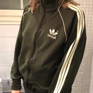 Vintage Adidas tröja - Adidas tröja med dragkedja i en militär/mörkgrön färg (kan skicka bättre bilder på färgen). Det är L men sitter som en M. Säljer för 250, är det många intressrade blir det budgivning. Frakt tillkommer på 63kr!💞