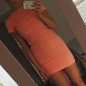  - Aprikosfärgad klänning ifrån NELLY i storlek M. Aldrig använd. Öppen i ryggen vilket är väldigt fint! 