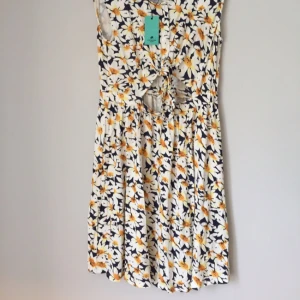  - Fin blommig klänning med fin knytning under bysten! 
Aldrig använd. 